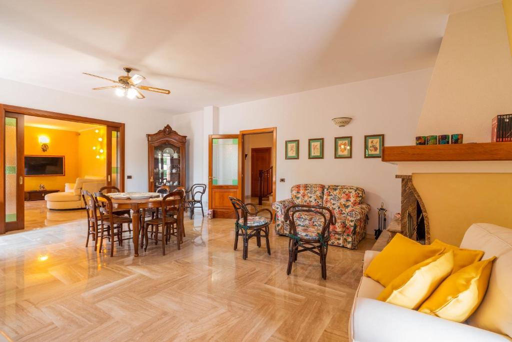 un salon avec un canapé, une table et des chaises dans l'établissement The Rosa's Luxury House, à Alezio