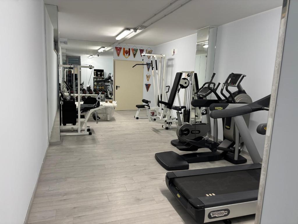 une salle de sport avec des tapis de course et des machines dans une pièce dans l'établissement Hotel Haus Charlotte, à San Benedetto del Tronto