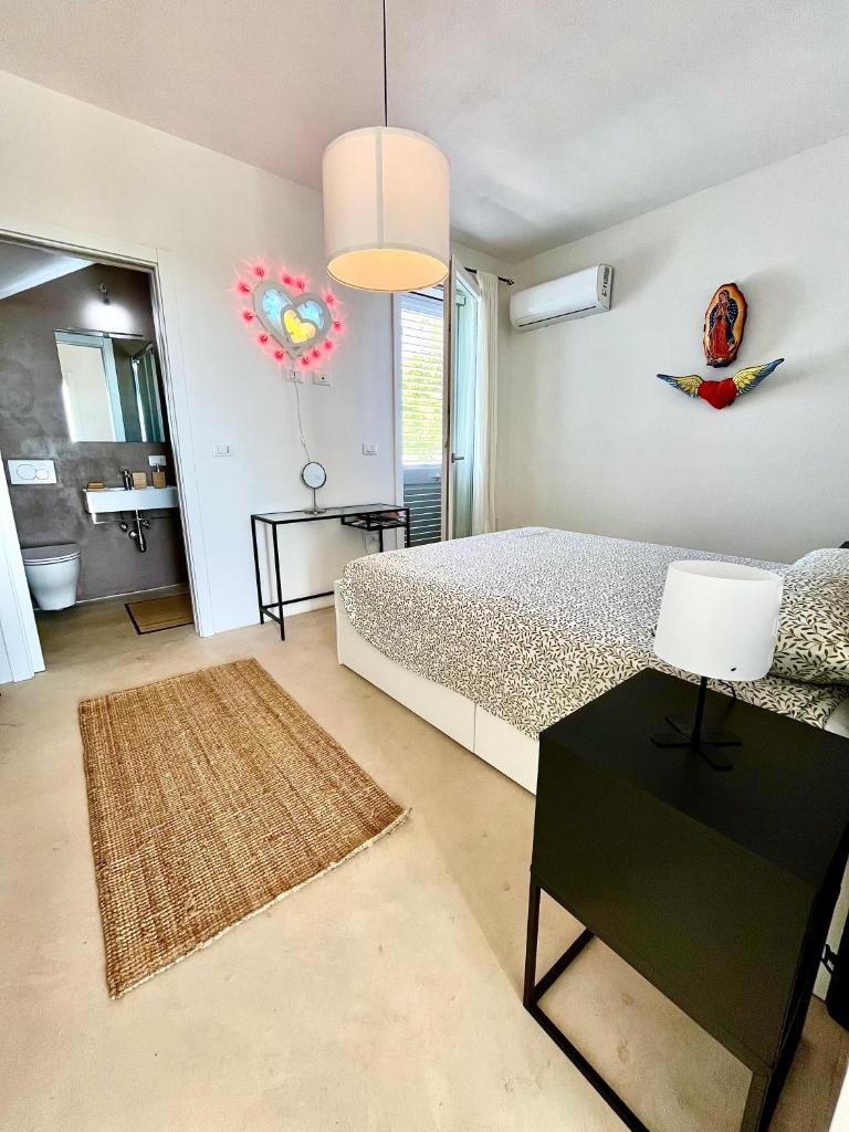 une chambre avec un lit et une table avec une lampe dans l'établissement Dimora Vereto, à Morciano di Leuca