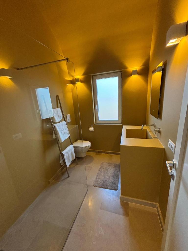 une salle de bain avec un lavabo et des toilettes dans l'établissement Villa Charme, à Ostuni