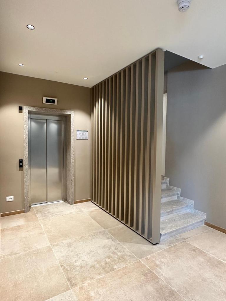 un hall avec un escalier et un ascenseur dans l'établissement Petit Hotel, à Caorle