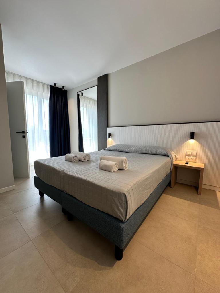 une chambre avec un grand lit avec des serviettes dessus dans l'établissement Petit Hotel, à Caorle