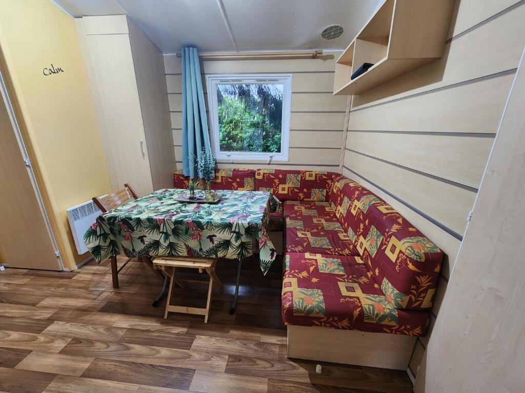 une salle à manger avec une table et un canapé dans l'établissement Charmant Mobil Home 6 personnes avec clim réversible, à Boofzheim
