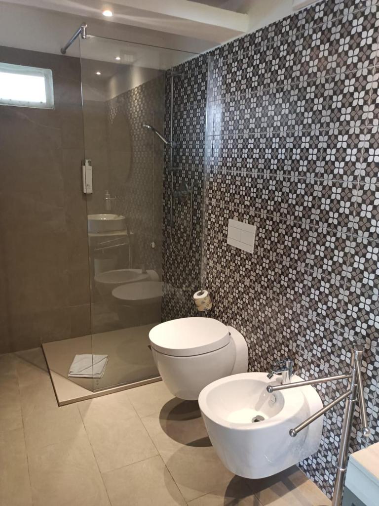 une salle de bain avec toilettes, douche et lavabo dans l'établissement Borgo di Riaci Beach Resort, à Santa Domenica 29 autres photos