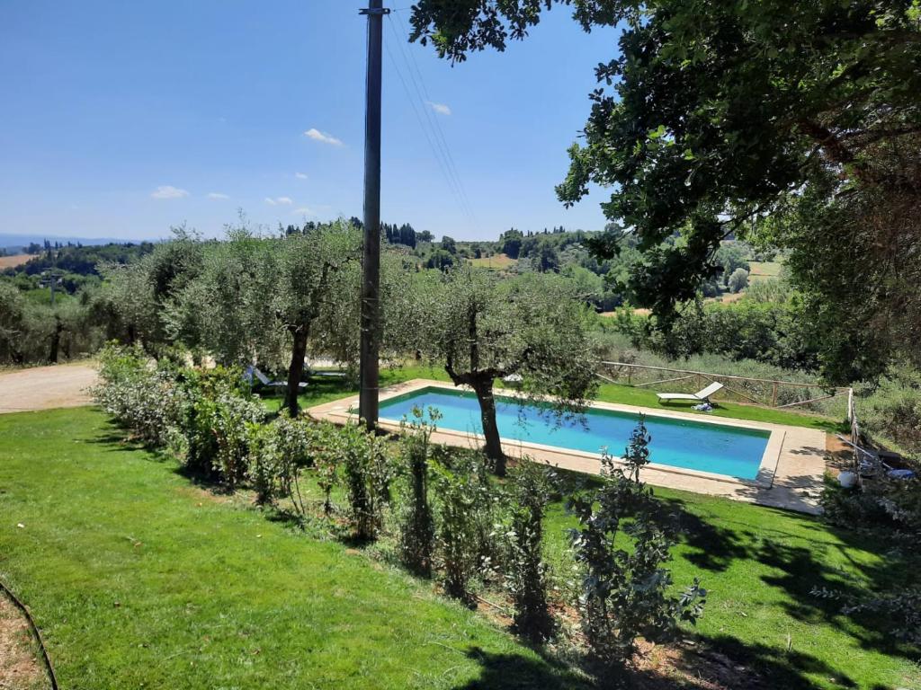 - une piscine dans une cour avec des arbres et de l'herbe dans l'établissement Il Poggio - Luxury villa in Tuscany, à Cetona