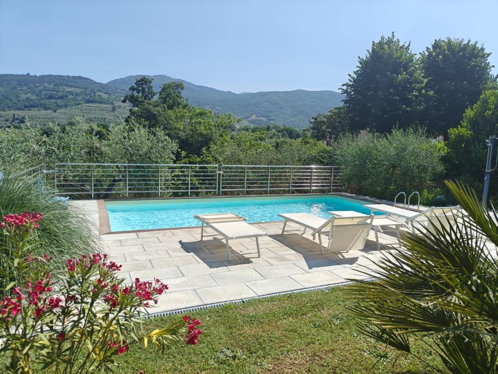 une piscine avec deux chaises et une table à côté dans l'établissement Casa Giovanna, à Castelfranco di Sopra