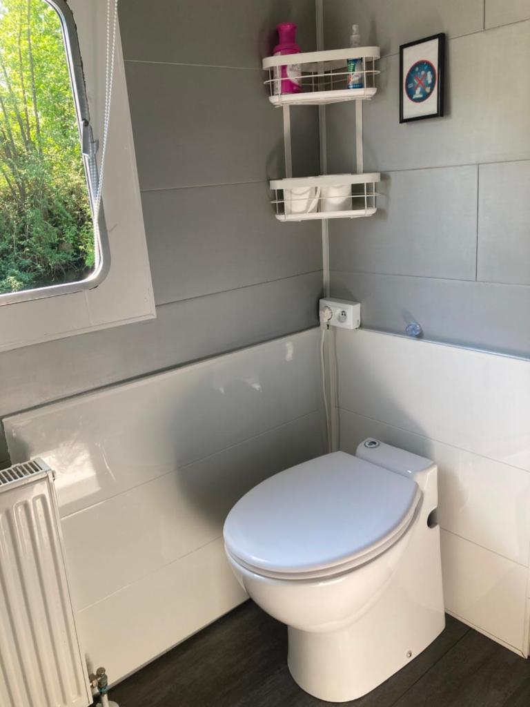 une salle de bain avec des toilettes blanches et une fenêtre dans l'établissement Une nuit, la vie avec Marie Lou, à Venette