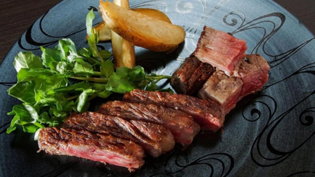 une assiette de nourriture avec de la viande et une salade dans l'établissement Tokiwa Hotel, à Kōfu
