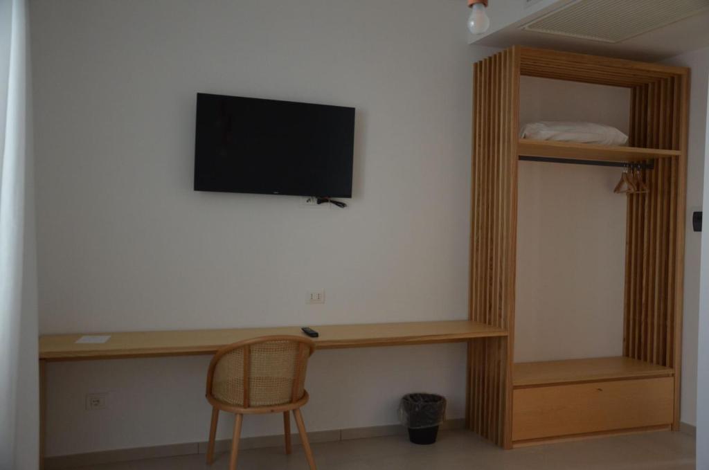 Cette chambre comprend un bureau et une télévision murale. dans l'établissement Hotel Venere, à Ascea
