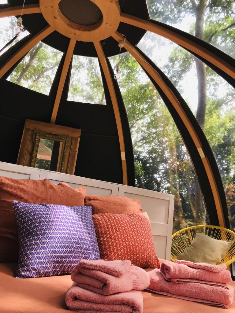 Cette chambre comprend un lit avec des oreillers et une fenêtre. dans l'établissement Ô cocon del Lauragués, à Ricaud 22 autres photos