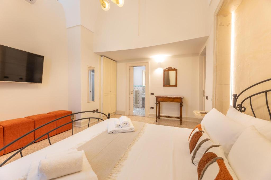 une chambre avec un lit, un canapé et une télévision dans l'établissement Villa Covile, à Casarano