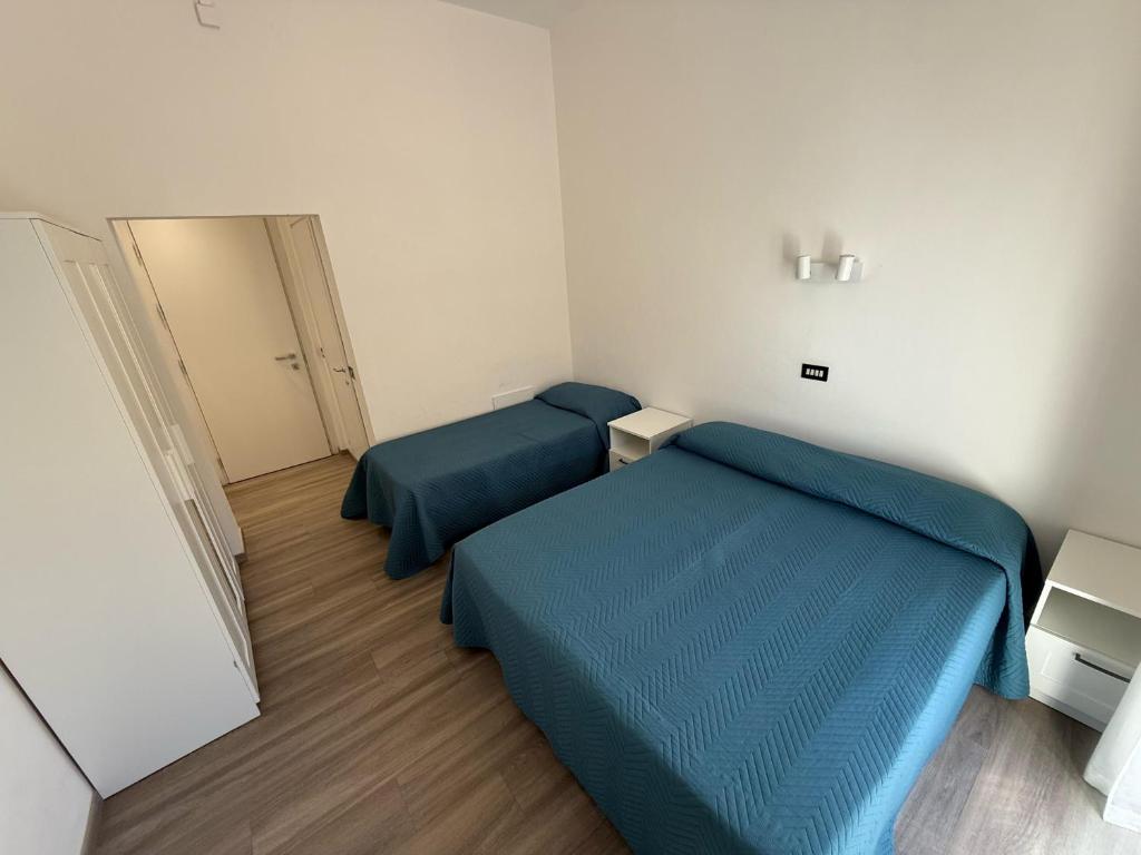 une petite chambre avec deux lits et un miroir dans l'établissement Hotel B&B Sole, à Senigallia