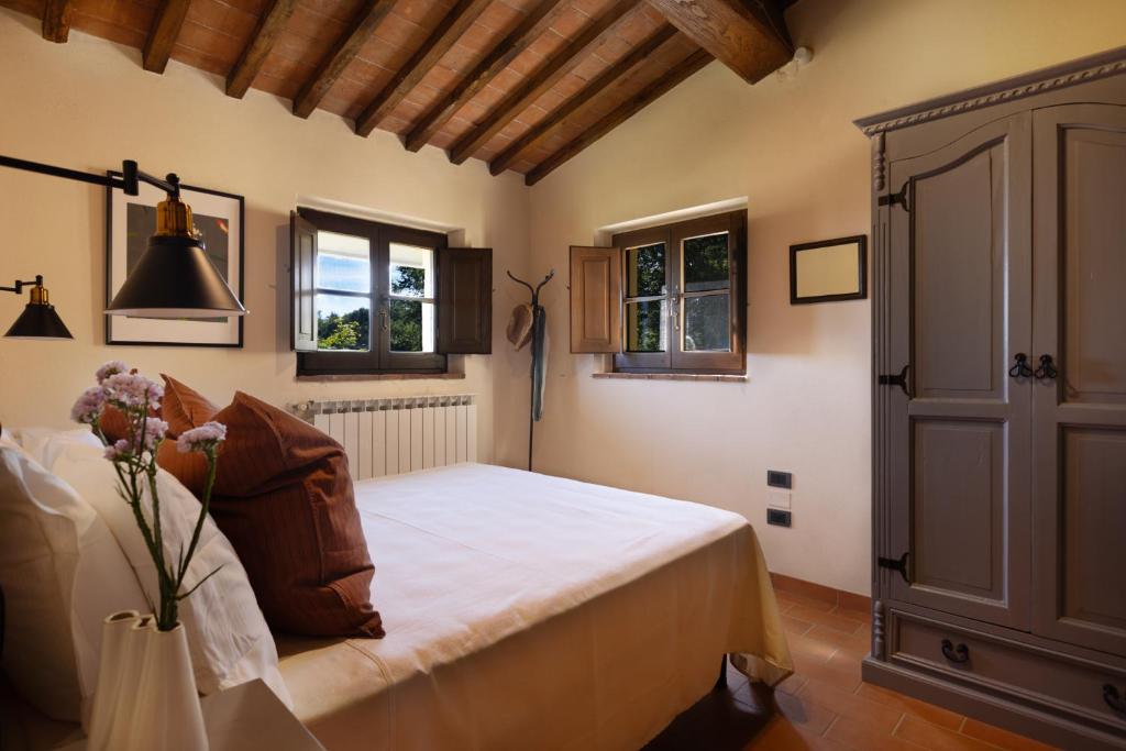 une chambre avec un lit et deux fenêtres dans l'établissement PODERE SAN LORENZO 12, Emma Villas, à Celle sul Rigo