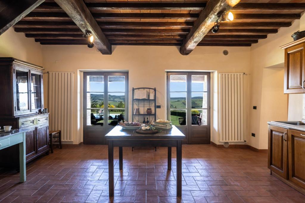 - une cuisine avec une table au milieu d'une pièce dans l'établissement PODERE SAN LORENZO 12, Emma Villas, à Celle sul Rigo