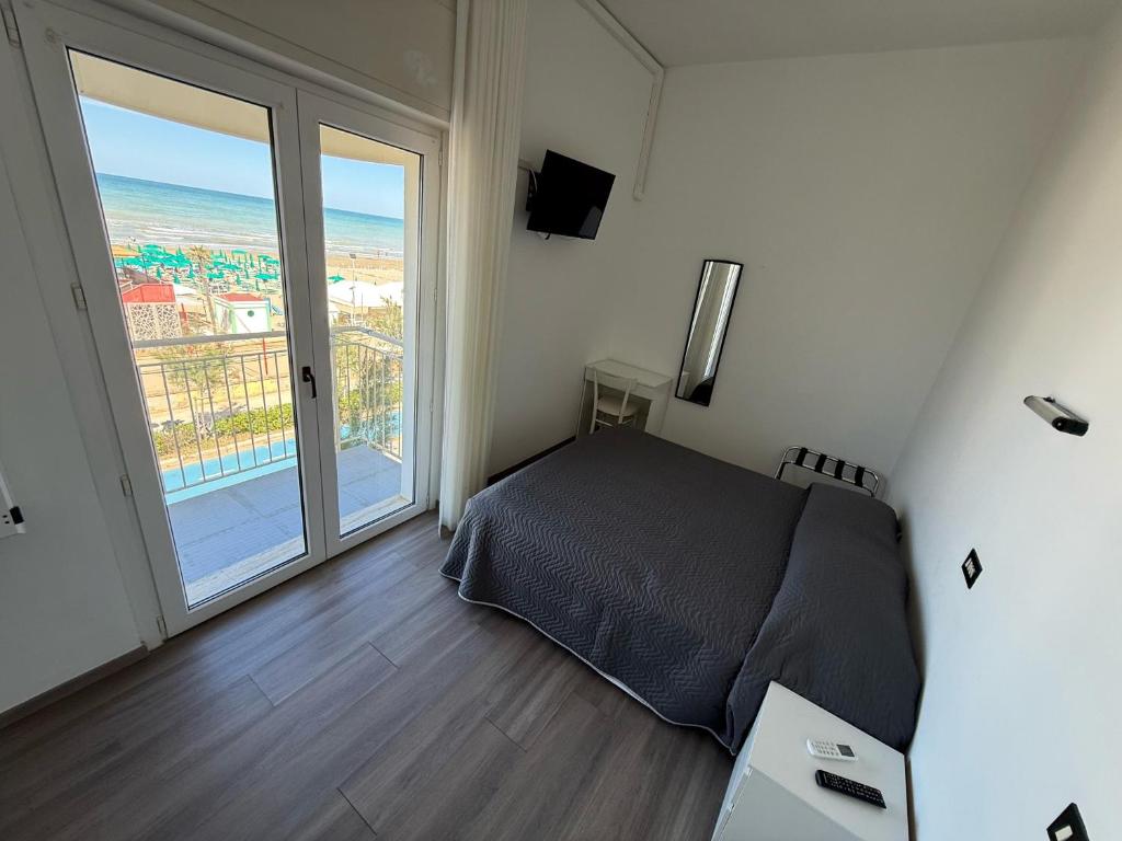 une chambre avec un lit et une grande fenêtre dans l'établissement Hotel B&B Sole, à Senigallia