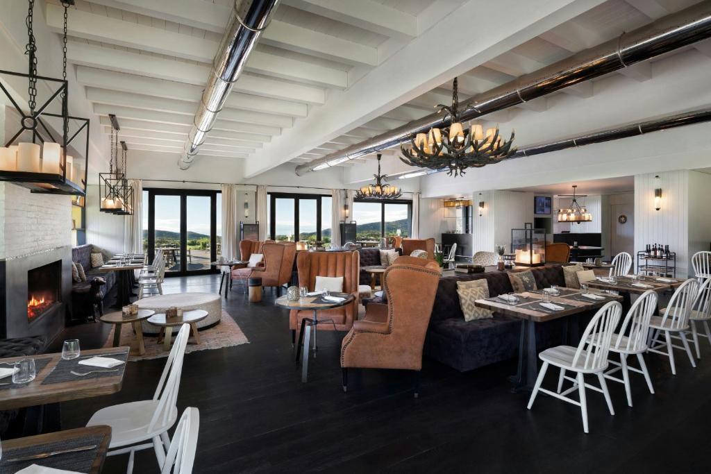 une salle à manger avec tables et chaises et une cheminée dans l'établissement Argentario Golf & Wellness Resort, Autograph Collection, à Porto Ercole