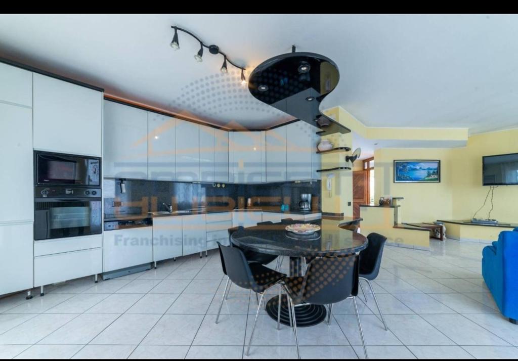 une grande cuisine avec une table et des chaises. dans l'établissement Villa Idea, à Lenno