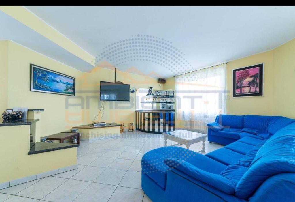 un salon avec un canapé bleu et une télévision dans l'établissement Villa Idea, à Lenno