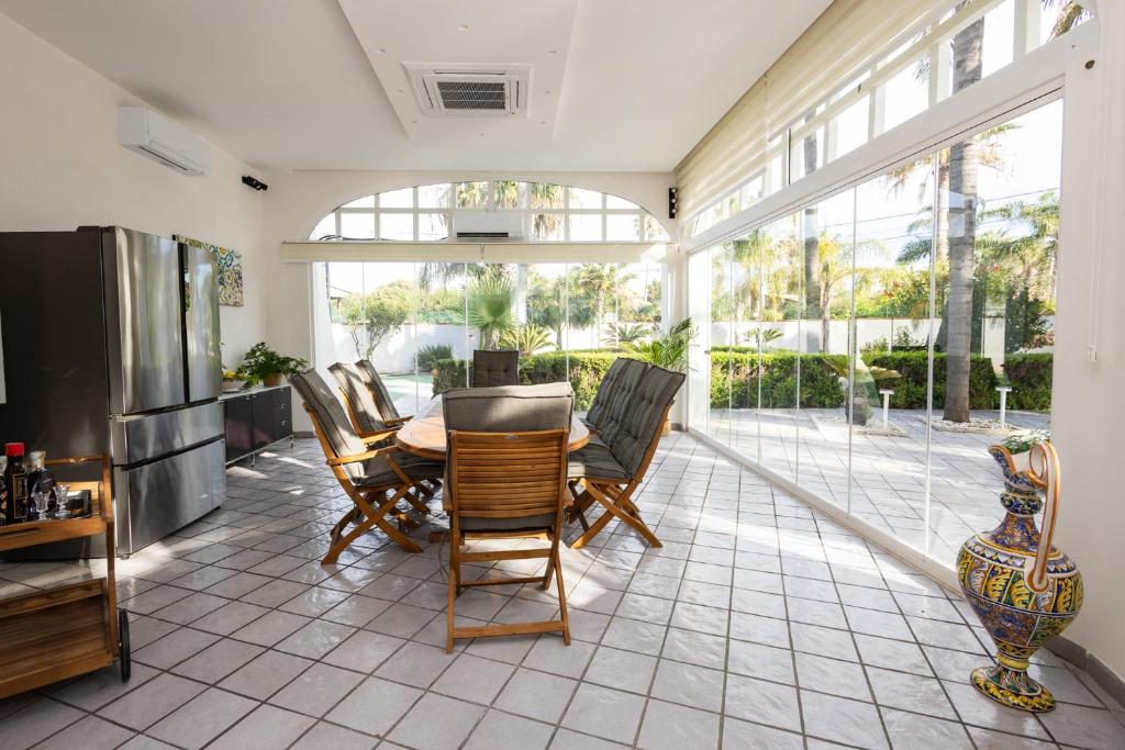 une salle à manger avec une table et des chaises et une grande fenêtre dans l'établissement Sea Relais Marsala, à Lido Signorino