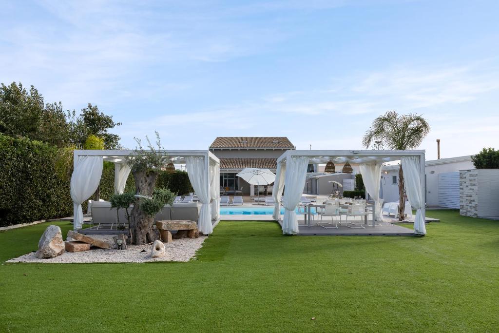 une cour avec un kiosque et une piscine dans l'établissement Villa Gemma mare e piscina riscaldata, à Santa Maria Del Focallo