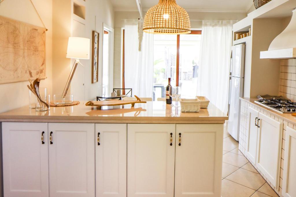 une cuisine avec des placards blancs et une grande fenêtre dans l'établissement Villa Erika piscina privata, à Ispica