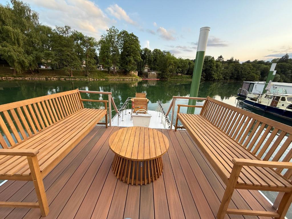 un pont avec deux bancs et une table sur un bateau dans l'établissement Charmant bateau sur la Marne, à La Ferté-sous-Jouarre