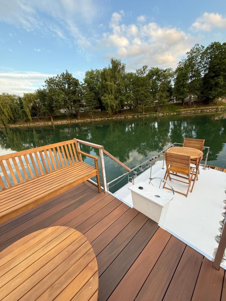 un pont avec deux bancs et une table sur un bateau dans l'établissement Charmant bateau sur la Marne, à La Ferté-sous-Jouarre