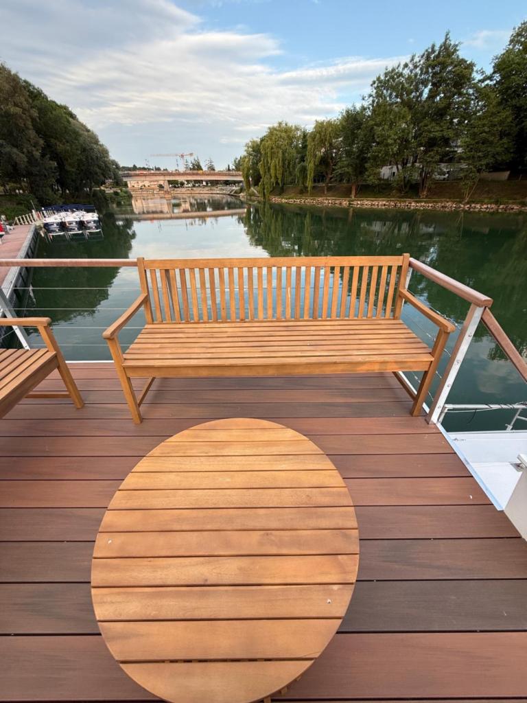 un banc en bois installé au-dessus d'une promenade en bois dans l'établissement Charmant bateau sur la Marne, à La Ferté-sous-Jouarre 8 autres photos