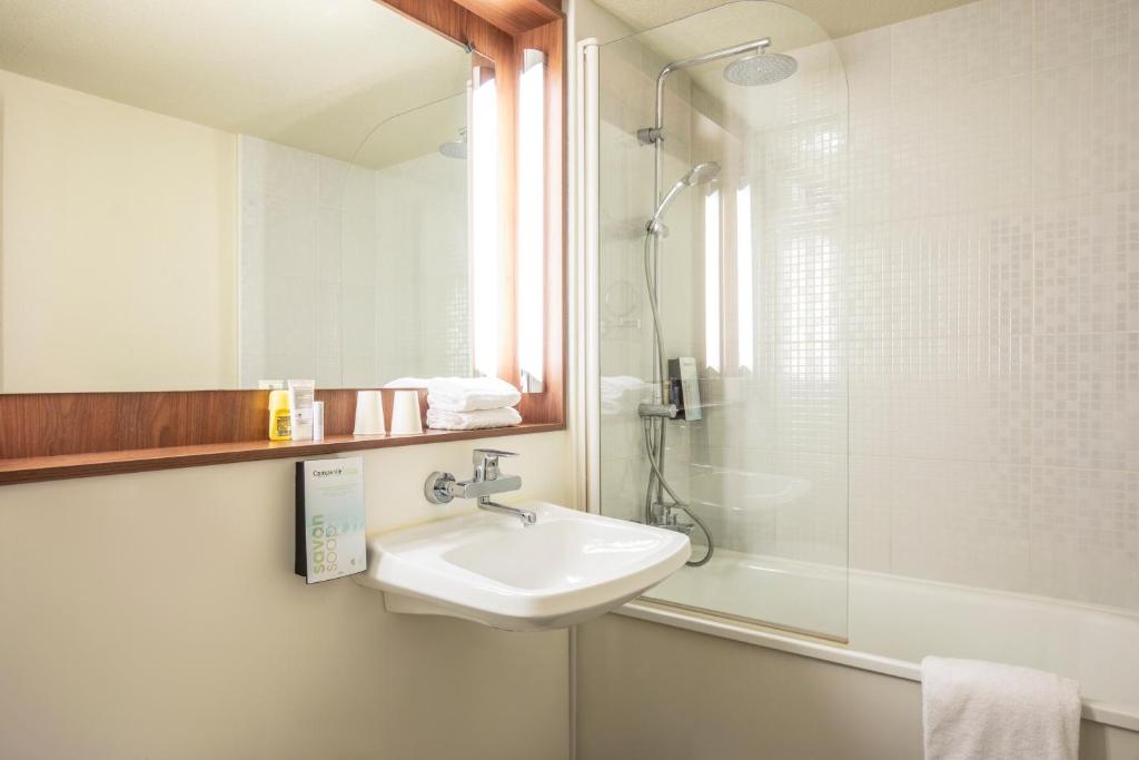 une salle de bain avec un lavabo et une douche dans l'établissement Campanile Pontarlier, à Pontarlier