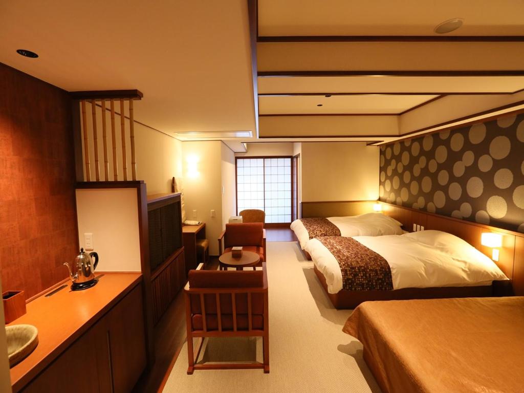 une chambre avec un lit, un bureau et un lavabo dans l'établissement Suiun, à Hakone