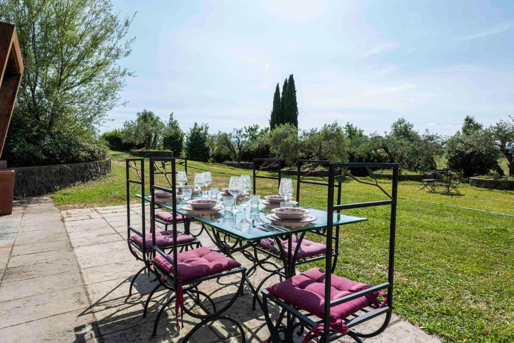 une table avec des chaises roses et des verres dessus dans l'établissement Villa al Vento by Mmega, à Levane