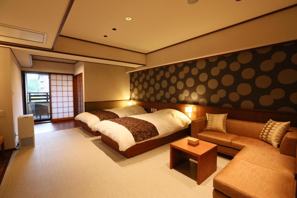 une chambre avec un lit et un canapé dans l'établissement Suiun, à Hakone