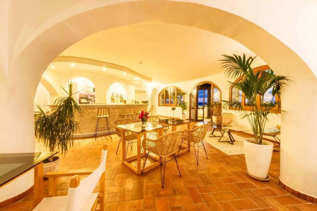 - un salon avec une voûte, une table et des chaises dans l'établissement Hotel Pedra Santa, à Baja Sardinia