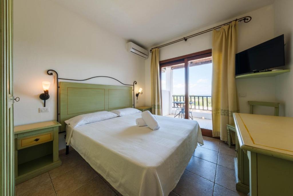 une chambre d'hôtel avec un lit et un balcon dans l'établissement Hotel Pedra Santa, à Baja Sardinia