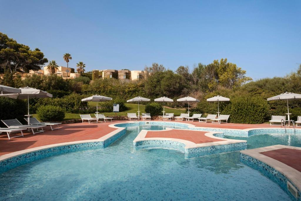 une grande piscine avec chaises et parasols dans l'établissement Mangia's Brucoli, Sicily, Autograph Collection, à Brucoli