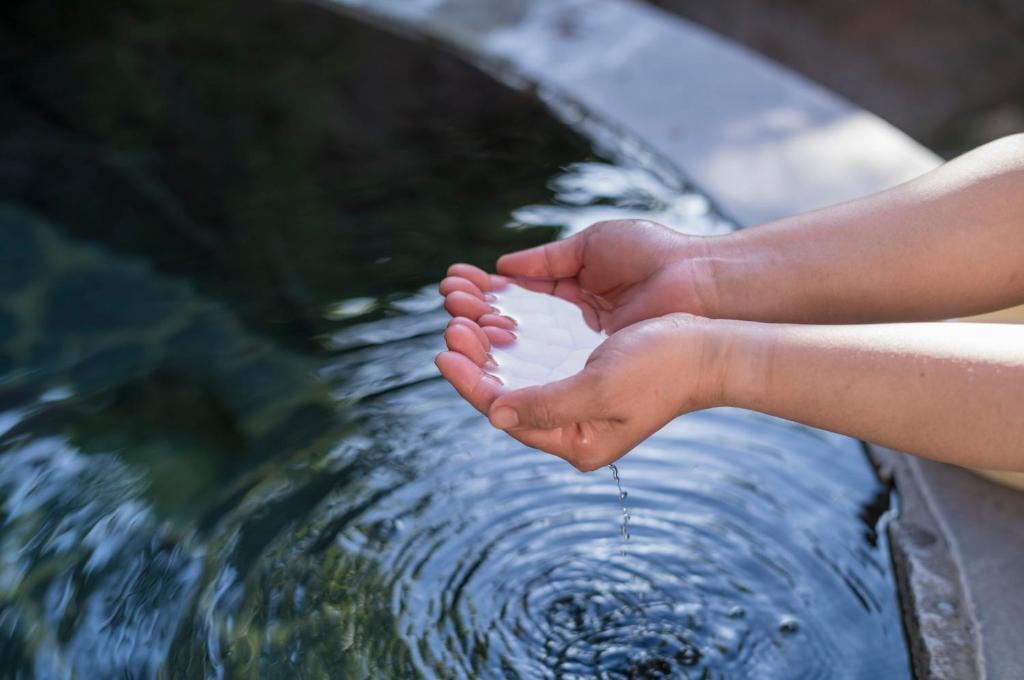 un enfant se lave les pieds dans un jet d'eau dans l'établissement 焼乃湯, à Takayama