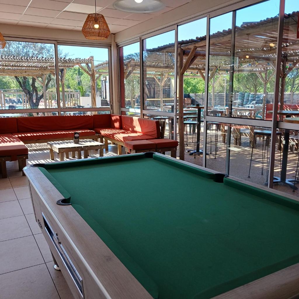 - un billard dans une salle avec des canapés et des tables dans l'établissement Bien être en 5 étoiles au cœur du sud Ardèche, Domaine de Chaussy, rivières vignobles et villages classés, à Lagorce