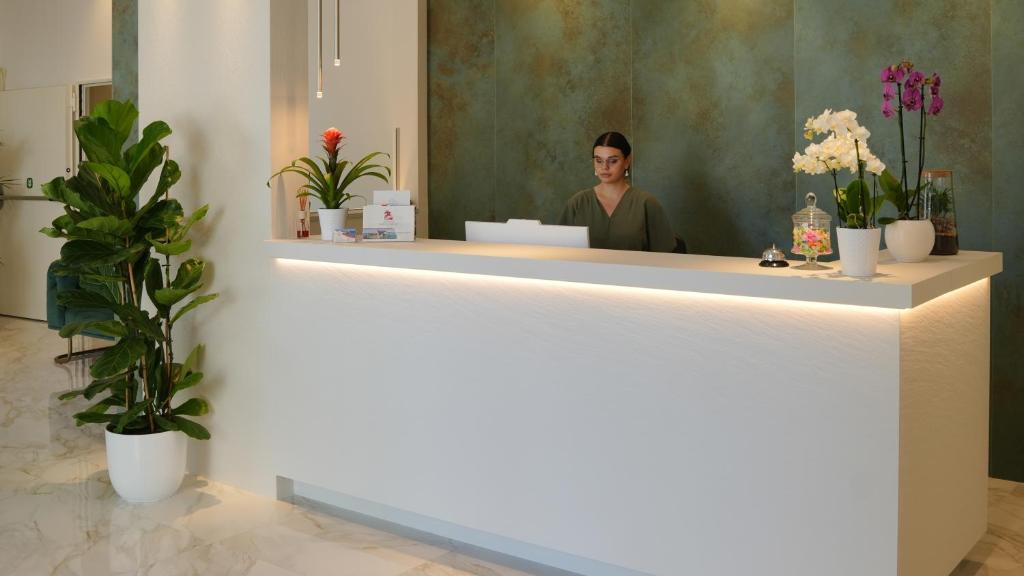 un homme debout à un comptoir dans un salon dans l'établissement Albergo San Giorgio, à Vieste