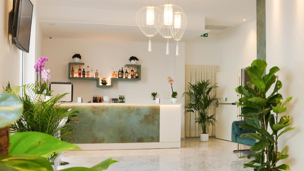 un salon avec des plantes et un comptoir dans une pièce dans l'établissement Albergo San Giorgio, à Vieste