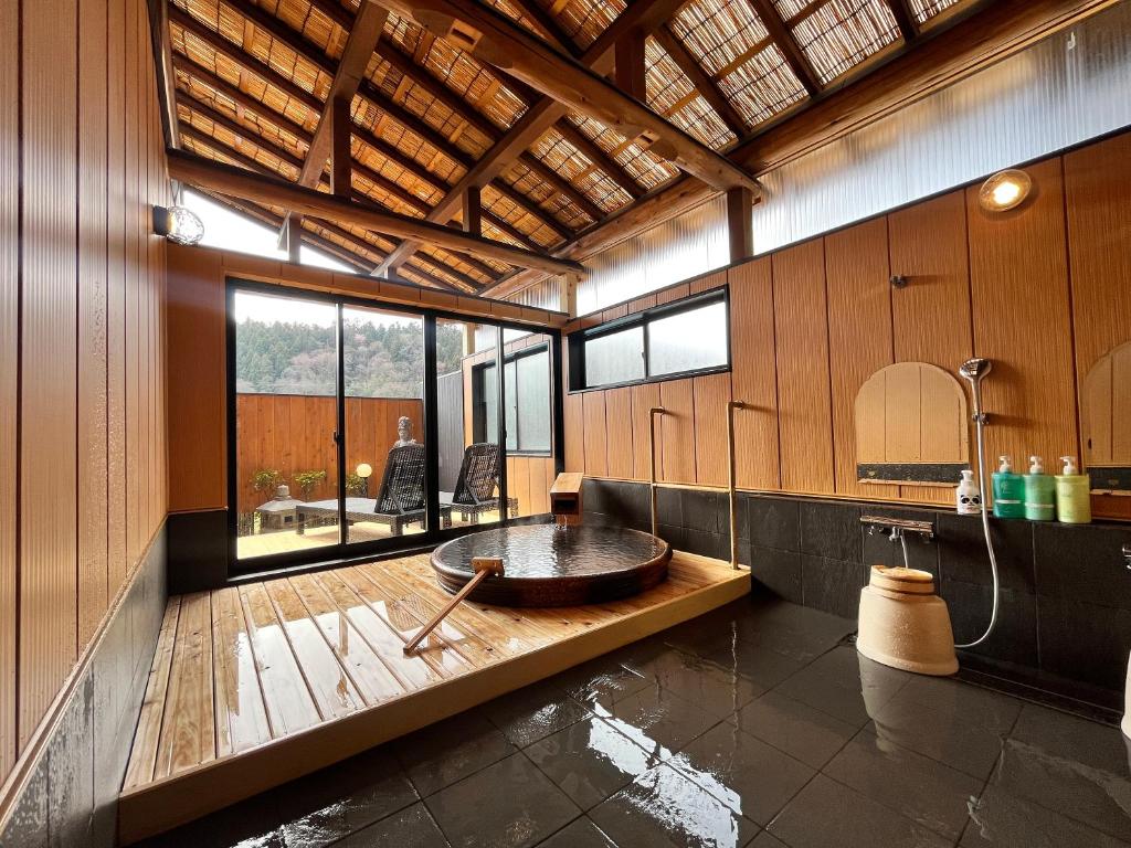une salle de bain avec une baignoire au milieu d'une pièce dans l'établissement Taiyokan, à Minakami