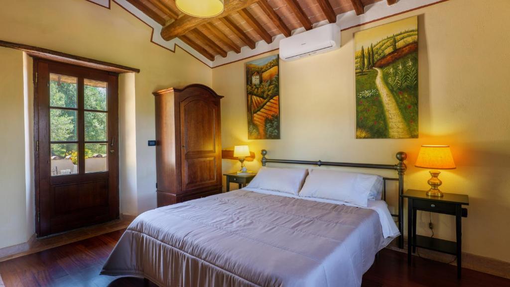 Cette chambre comprend un lit avec deux lampes et des peintures murales. dans l'établissement Montebendico 6, Emma Villas, à Castel del Piano