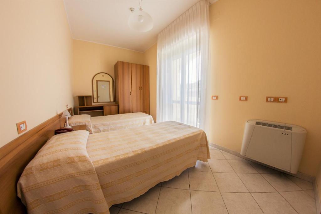 une chambre avec deux lits et une fenêtre dans l'établissement Hotel San Giorgio, à Vasto
