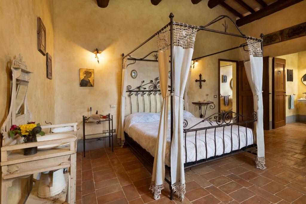 une chambre avec un lit à baldaquin dans une pièce dans l'établissement San Rocco 4, Emma Villas, à Montecchio