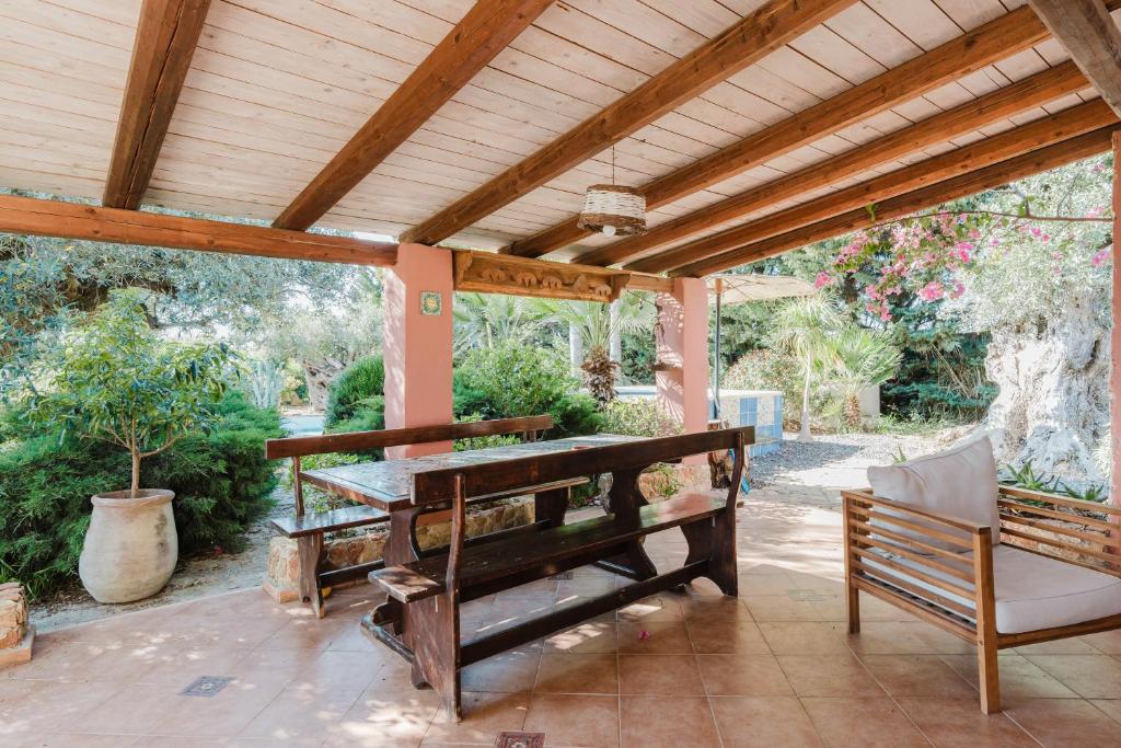 une pergola en bois avec une table et un banc dans l'établissement Casa Blandina, à Menfi