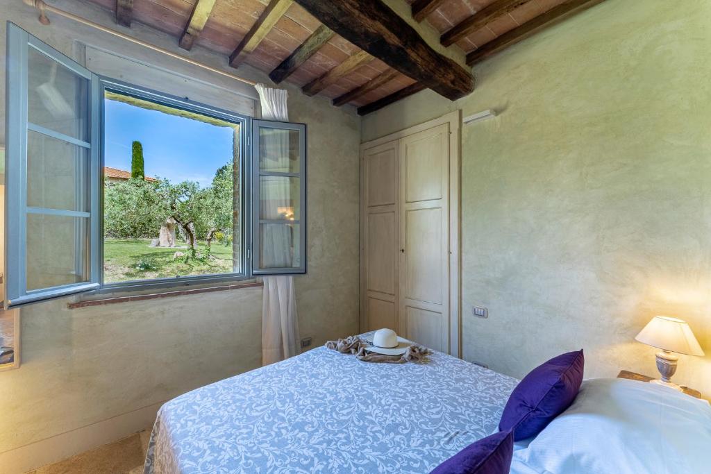 une chambre avec un lit et une fenêtre dans l'établissement L'Oliveta 6, Emma Villas, à Gambassi Terme