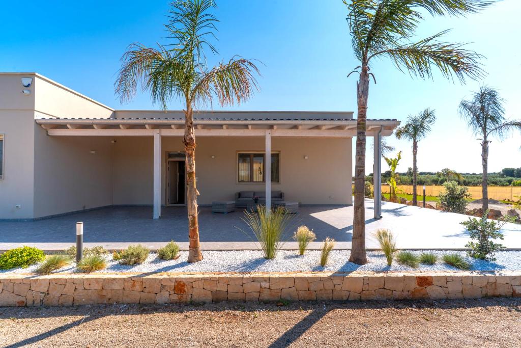 une maison avec des palmiers devant dans l'établissement Villa Red Wind by Perle di Puglia, à Nardò