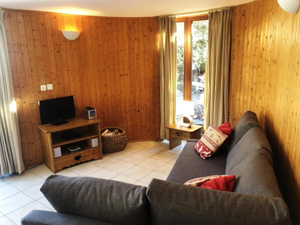 un salon avec un canapé et une télévision dans l'établissement Chalet Leslie, à Morzine