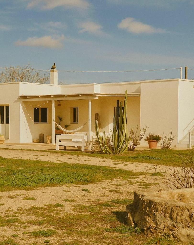 une maison blanche avec une clôture blanche devant elle dans l'établissement Casina del mandorlo Private Pool, à Maglie