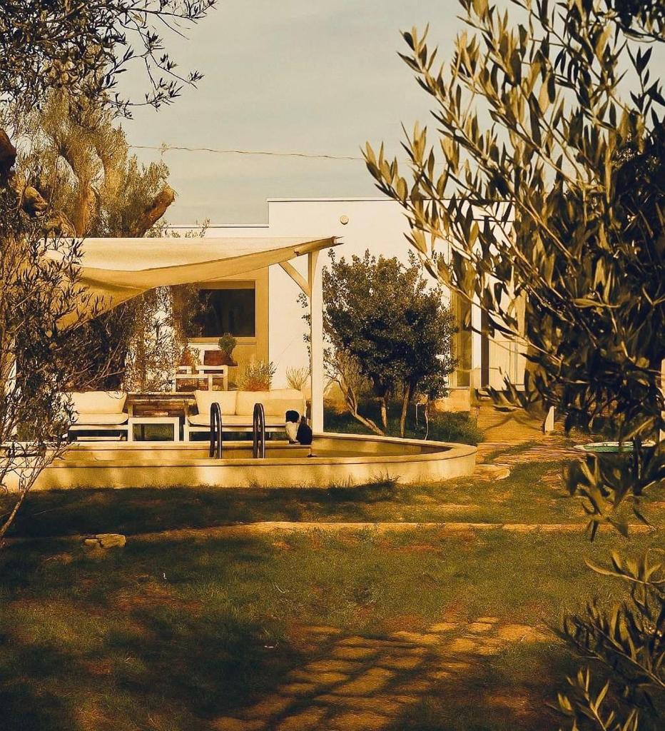 une maison avec un banc devant dans l'établissement Casina del mandorlo Private Pool, à Maglie