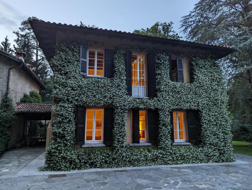 une maison couverte de lierre avec des portes et des fenêtres orange dans l'établissement Villa Riva Bellagio with Pool & Garden by Rent All Como, à Bellagio